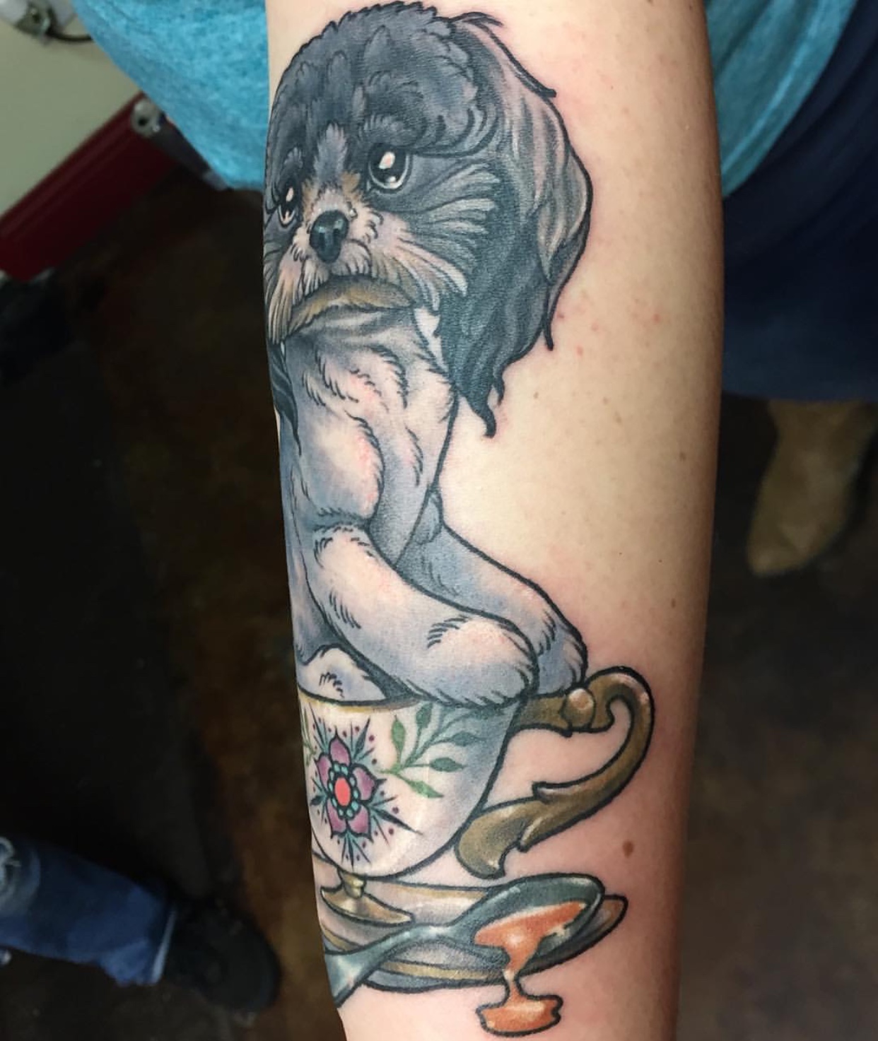 Shih Tzu sitting on a cup tattoo on the forearm