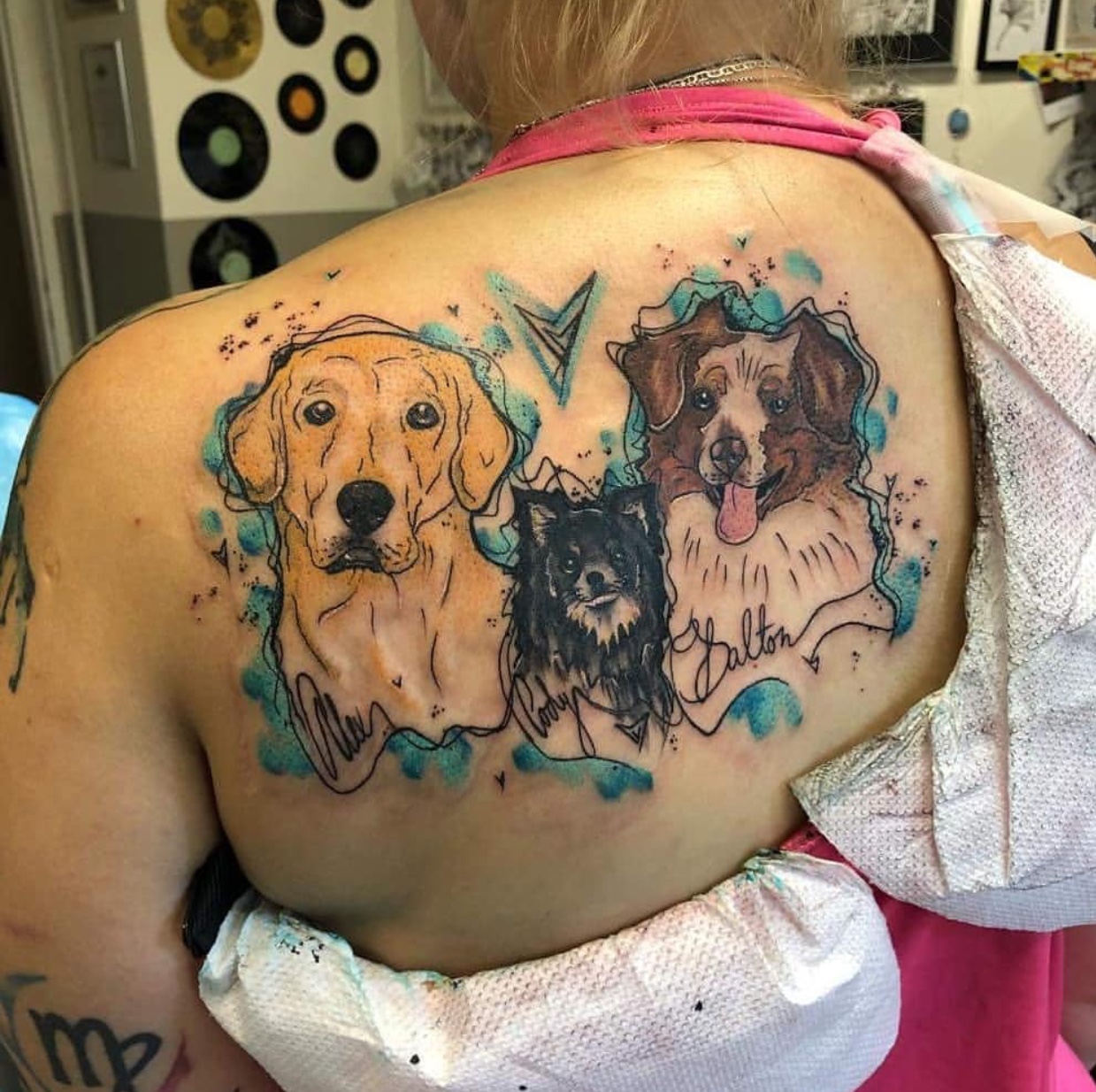 Artistic Labrador Retriever, chihuahua, and border collie tattoo on the back of a woman