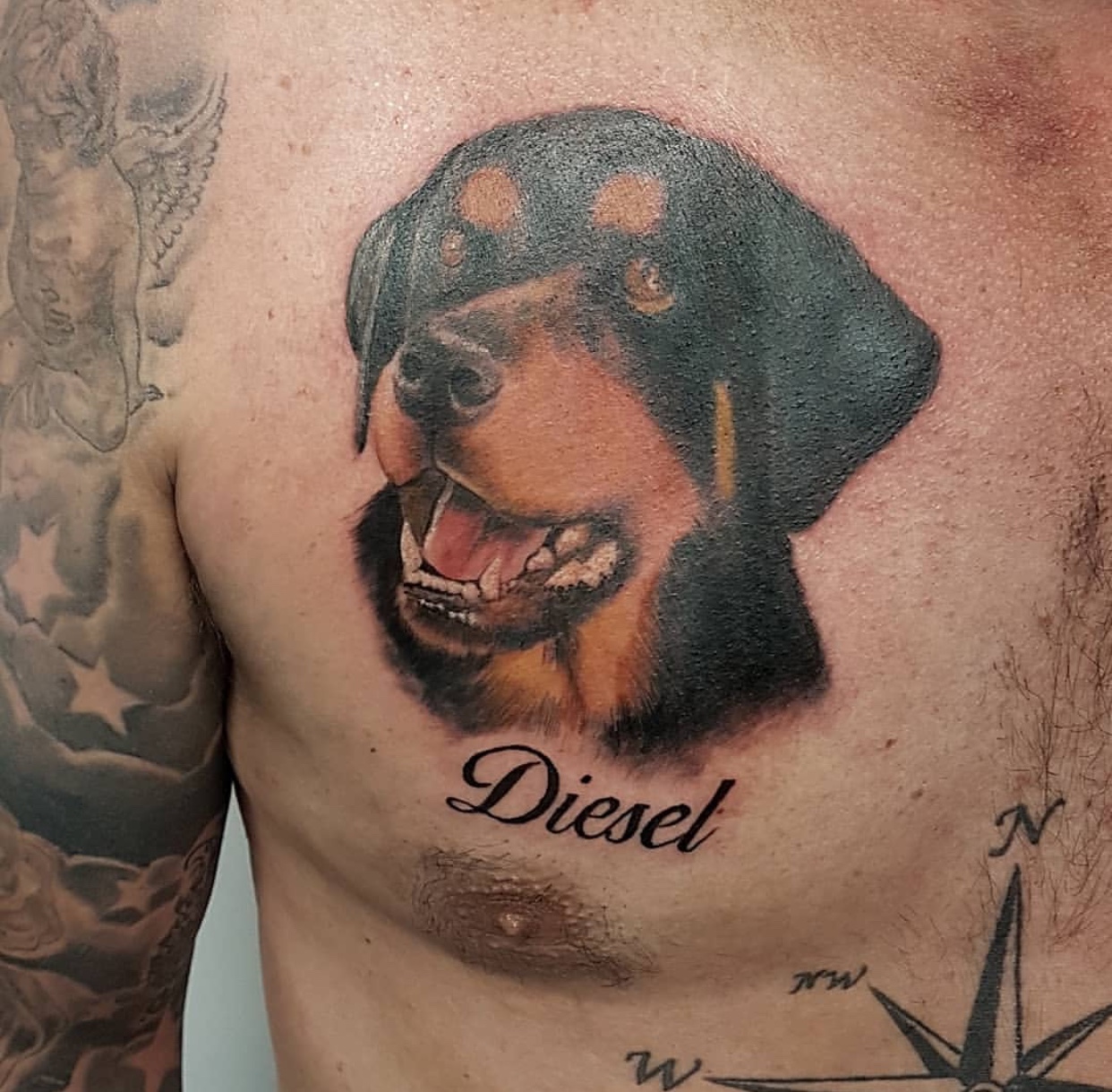 face of a Rottweiler looking up with its mouth open tattoo on the chest with name 