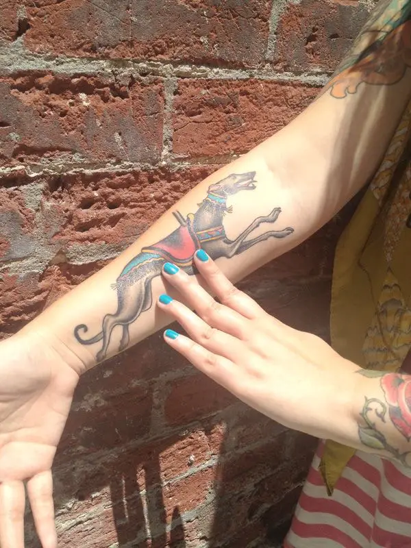 Greyhound runner tattoo on the forearm