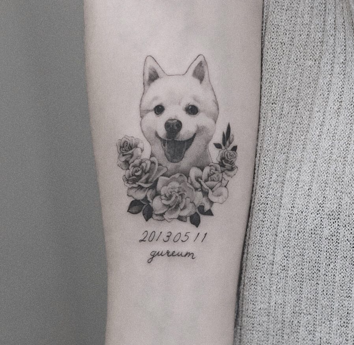 happy Pomeranian with flowers tattoo on the forearm