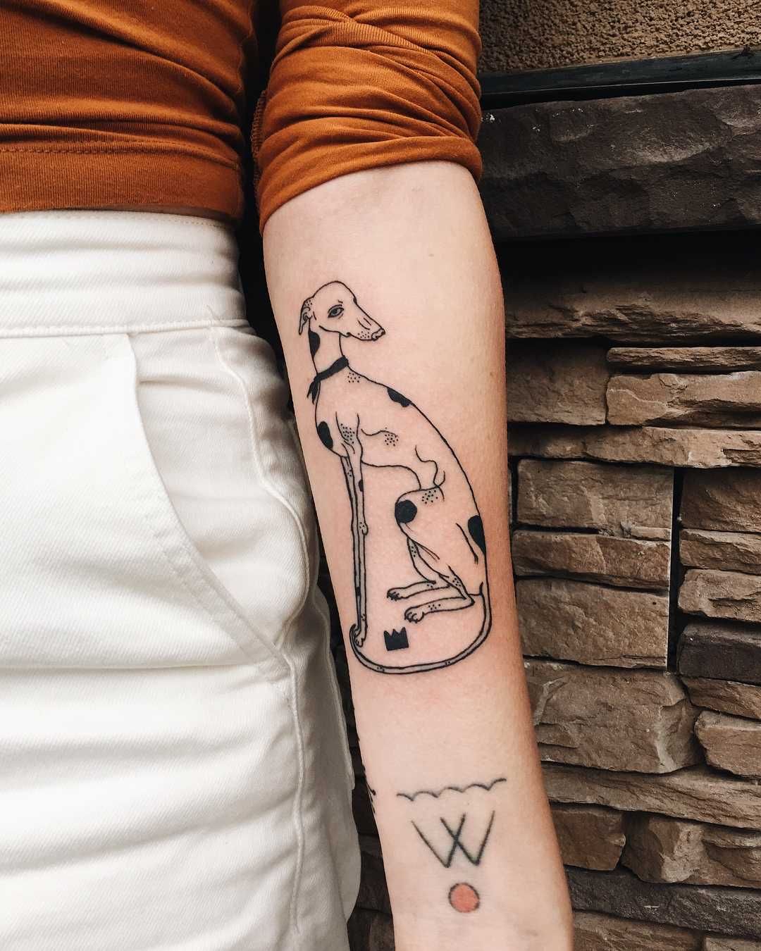 sitting Greyhound tattoo on the forearm