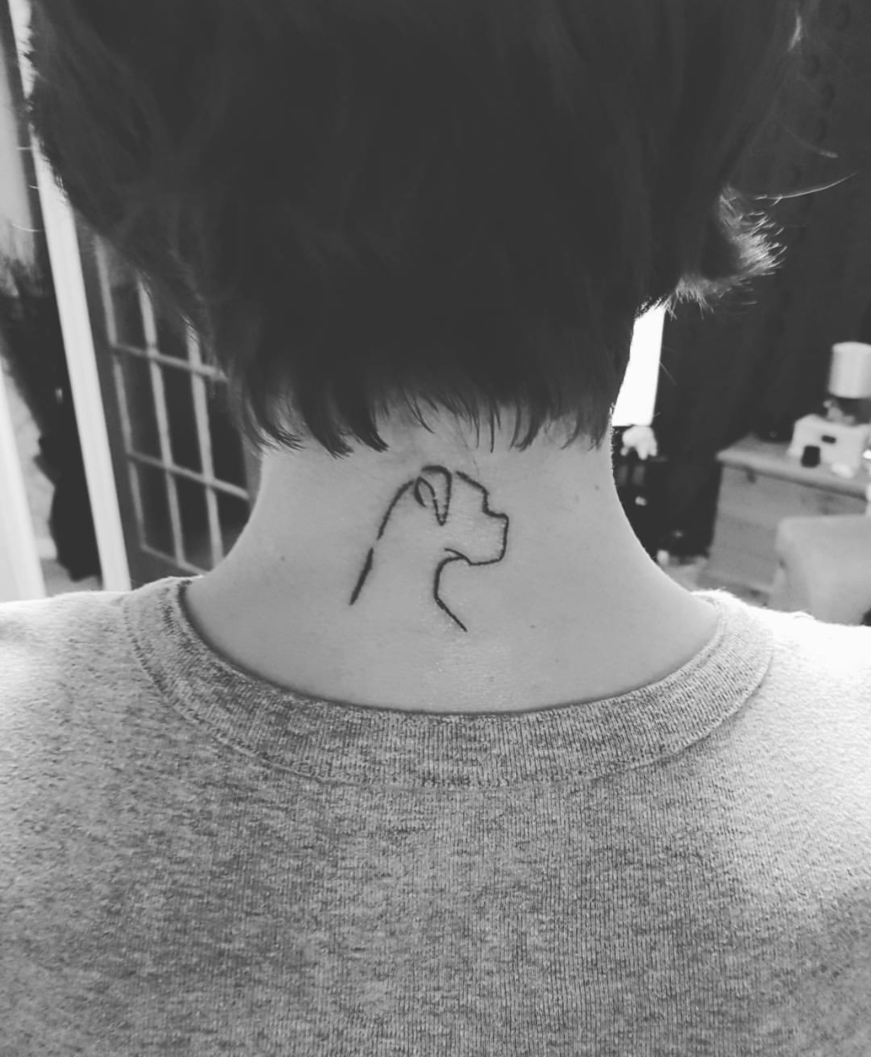 An outline of a Boxer tattoo on the back of the neck
