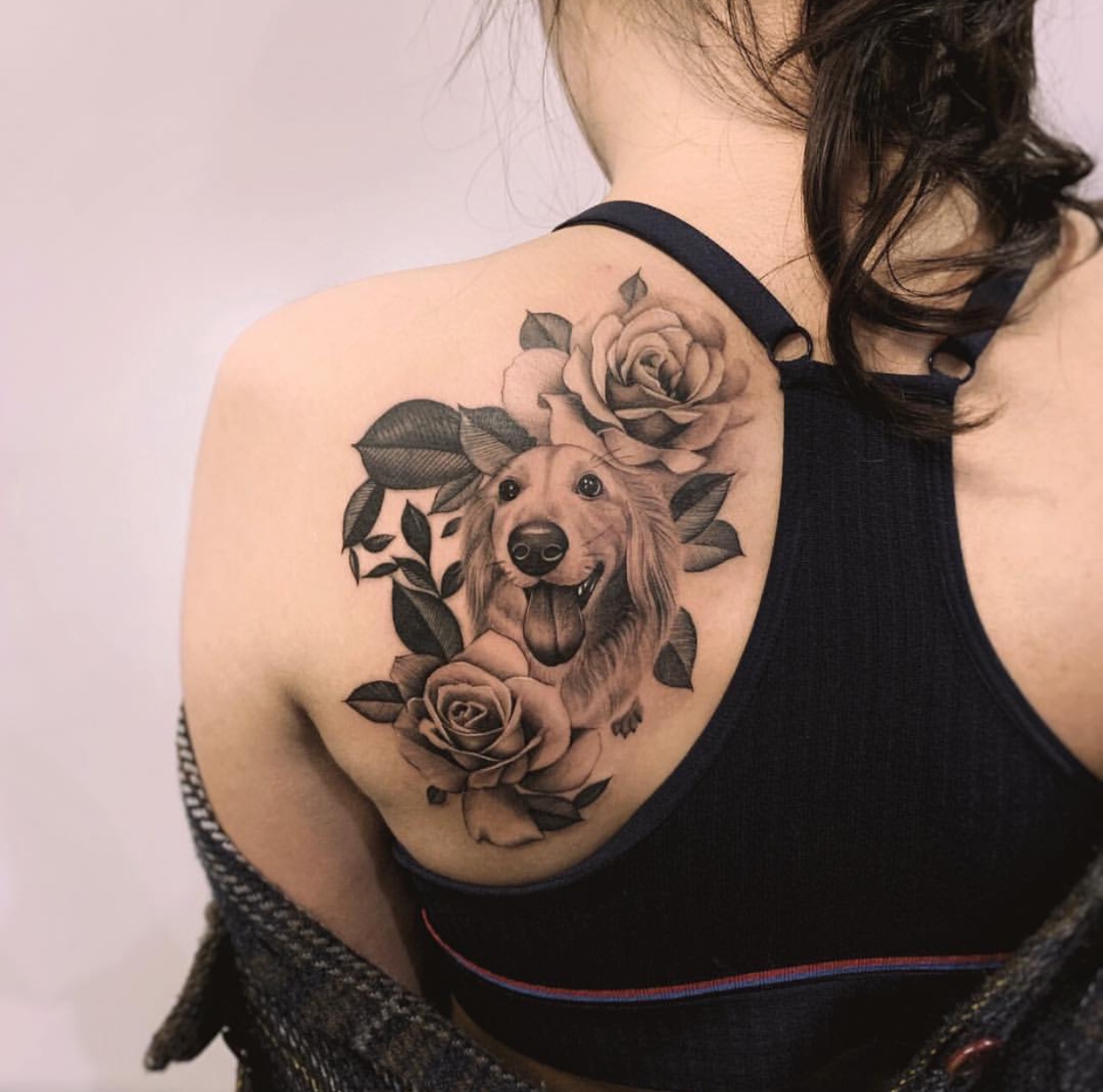 smiling Dachshund with roses tattoo on the back