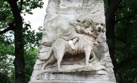 A St. Bernard Dog monument with a kid hugging him while riding his back