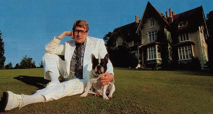 Yves Henri Donat Mathieu-Saint-Laurent sitting in the yard with his French Bulldog sitting beside him