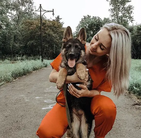 A woman holding her German Shepherd puppy