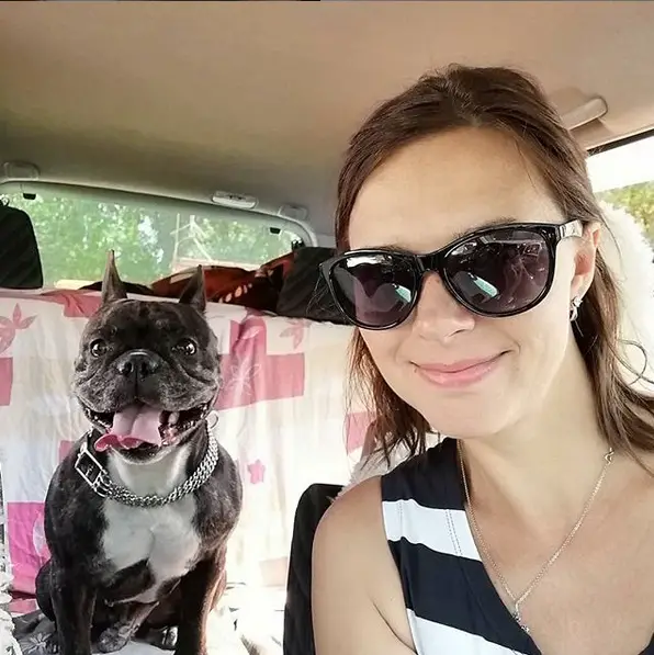 A woman taking a selfie with her French Bulldog at the back