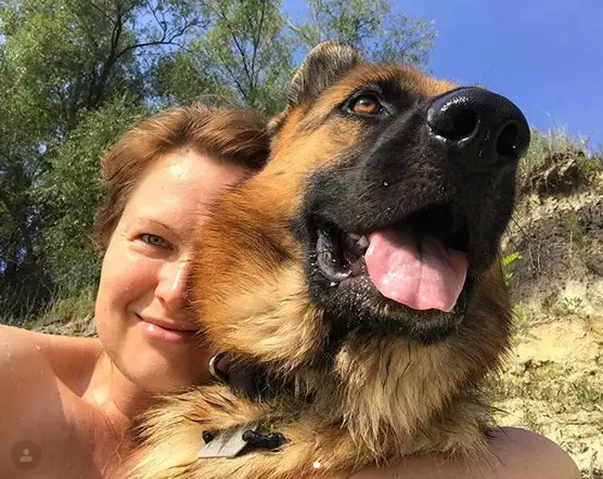 A woman taking a selfie with her German Shepherd