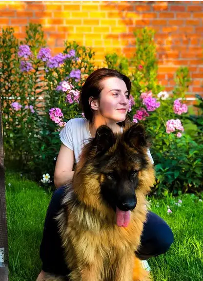 A woman in the yard with her German Shepherd
