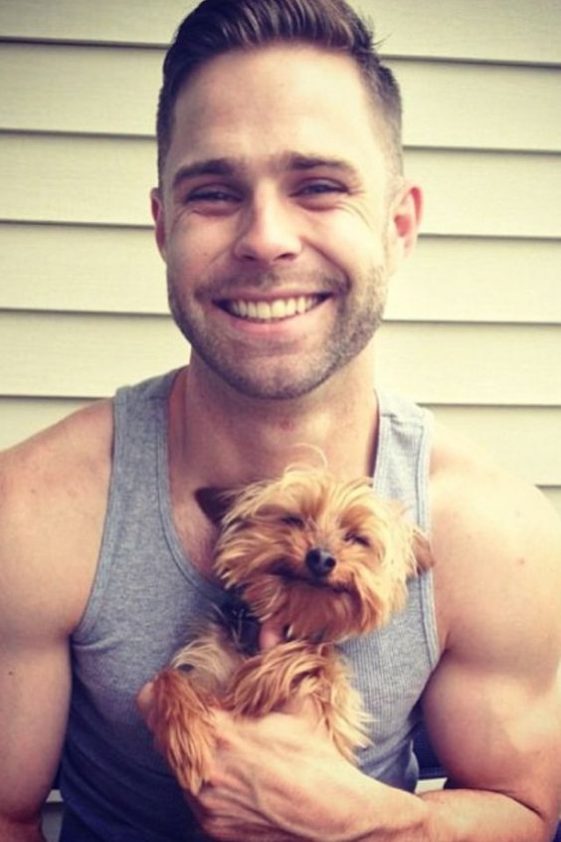 Holding a Yorkshire Terrier with a smile on his face