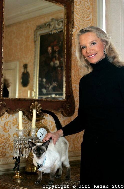 Princess Michael of Kent petting her Siamese Cat lying on the table