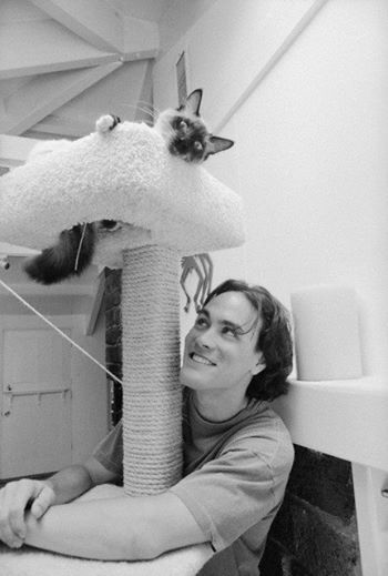 black and white photo of Brandon Lee under his Siamese Cat on top of the tower