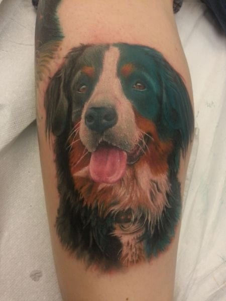 realistic happy Bernese Mountain Dog tattoo on the leg