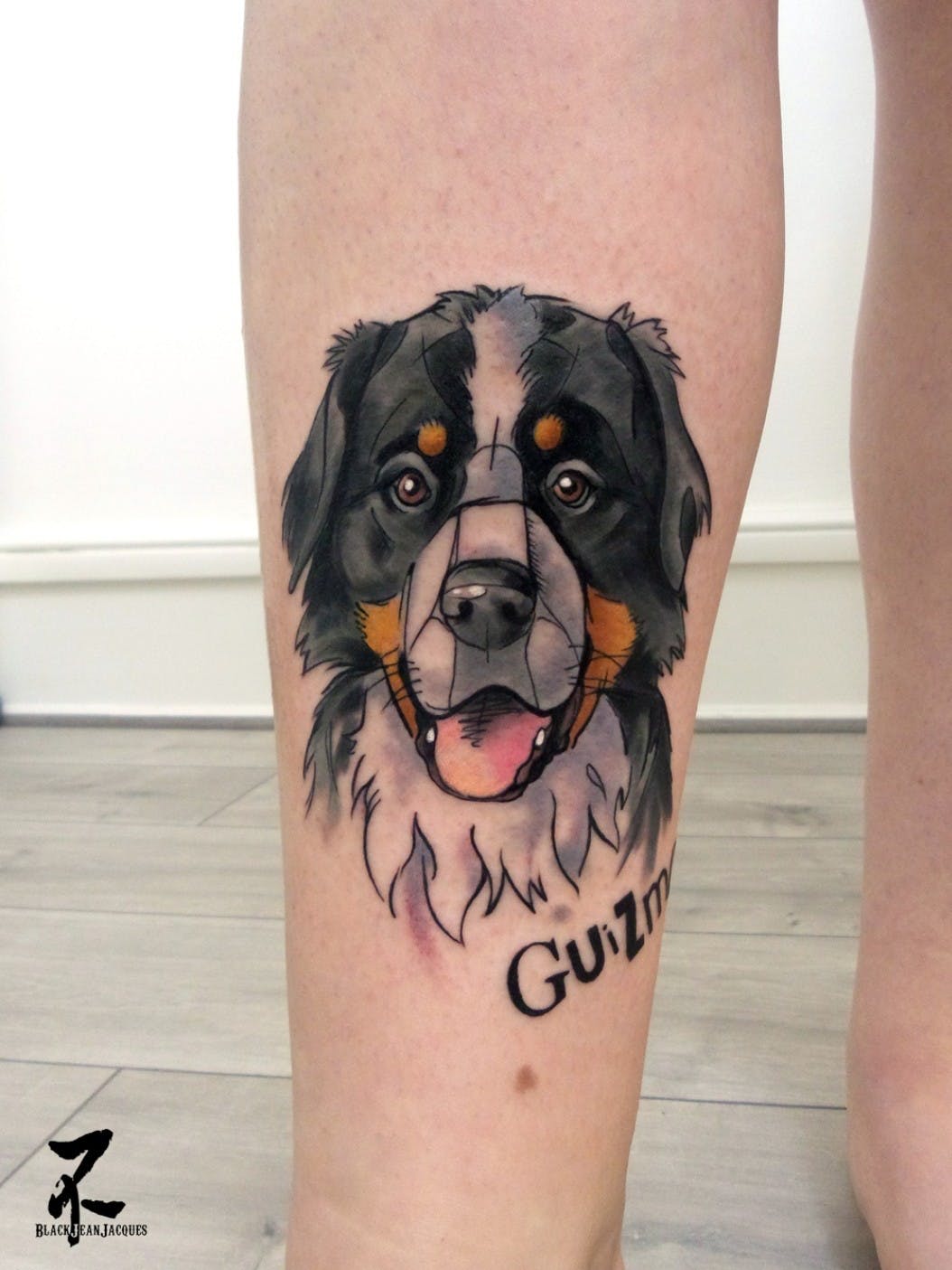A Cartoon style tattoo of a Bernese Mountain Dog on the leg