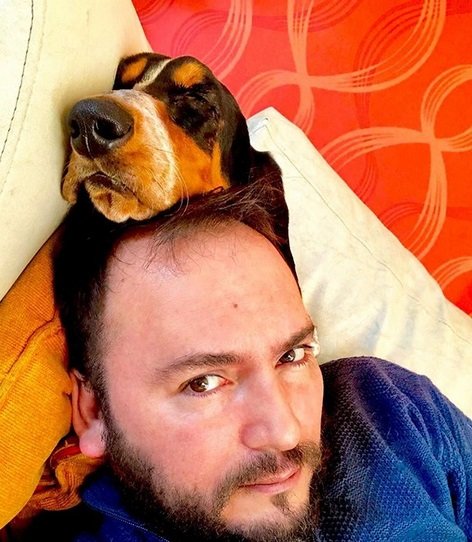 Basset Hound sleeping with its head on top of a person's head