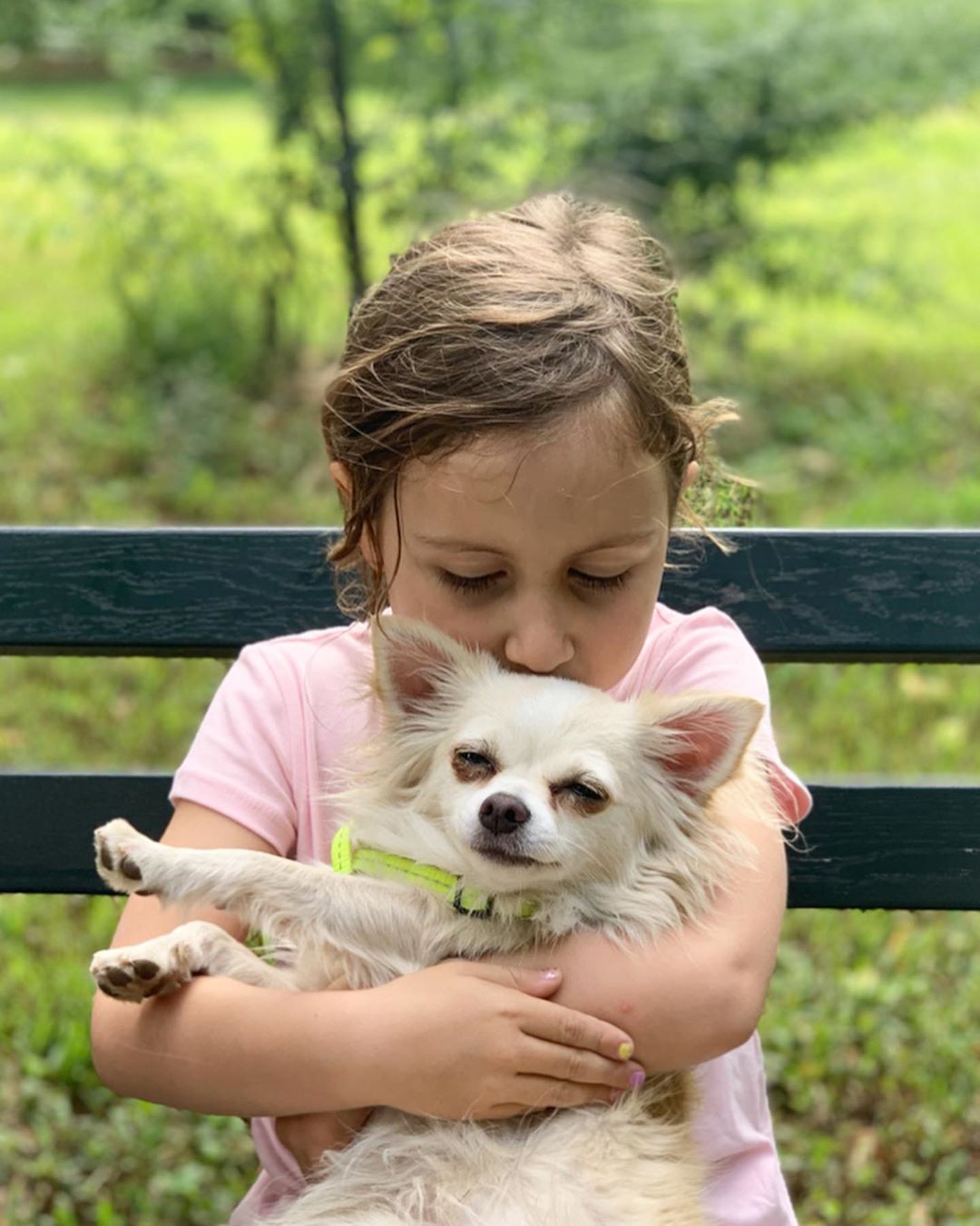 a girl kissing a white Chihuahua